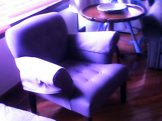 Sillón de brazo curvo con fundas en las coderas